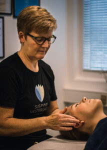 Behandler fra Susanne Vestergaard giver access bars behandling mod uro, hvor hænderne placeres blidt ved klientens hoved.
