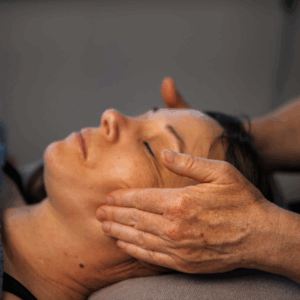 Kvinde får ansigtsmassage hos Susanne Vestergård, der arbejder med stressreduktion og afhjælpning af symptomer på stress gennem blid massage og nærværende behandling.