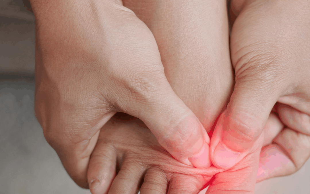 Person trykker på forfoden med begge hænder – tydeliggør smerter i forfod og tæer markeret med rødligt område.