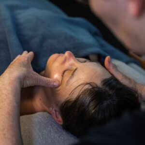 En kvinde får afslappende massage i kæben, som lindrer spændinger og hjælper mod kæbesmerter.