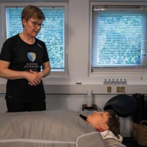 Kvinde får behandling med infrarød saunatæppe hos behandler for at lindre ubehag i kroppen og øge velvære.