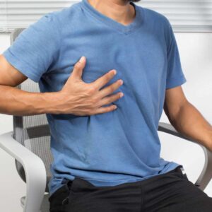 Mand der holder sig til brystet og oplever spændinger i brystet.