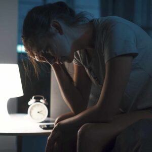 Kvinde sidder vågen om natten med uro og tankemylder – fokus på at få hjernen til at slappe af.