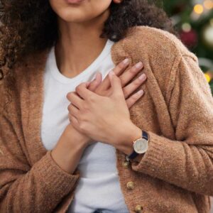 Kvinde holder sig til brystet på grund af spændinger i brystet.