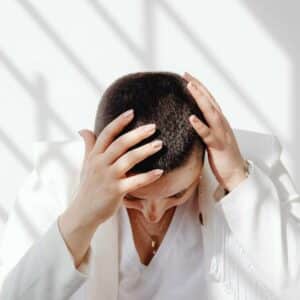 Person holder sig om hovedet på grund af smerter og pres hvad hjælper på hovedpine.