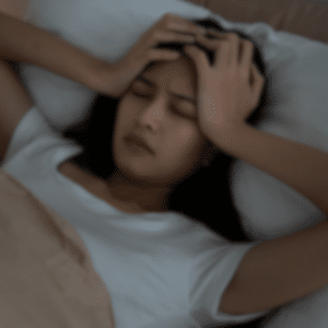 Kvinde der ligger vågen i sengen og mærker uro i kroppen illustrerer følelsen af søvnløshed og spørgsmålet hvorfor kan jeg ikke sove.