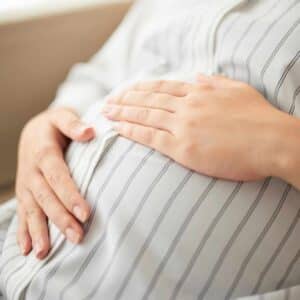 Gravid mave i roligt miljø, hvor akupunktur kan bruges som støtte under graviditet.