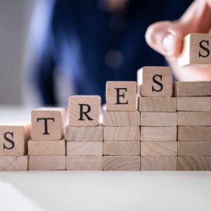 Træklodser med ordet stress som symbol på stress symptomer hos kvinder i en travl hverdag.