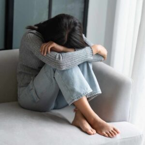 Stresset kvinde sidder alene som eksempel på behov for effektivt stressmanagement.