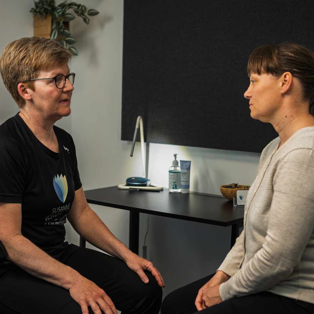 Samtale mellem behandler og kvinde om stress og sygemelding i klinik.